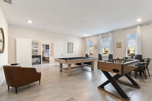 A spacious living area with a pool table, foosball table, and a comfortable seating area. - Storey Lake Resort Villa | Pool & Resort Fun (Kissimmee)