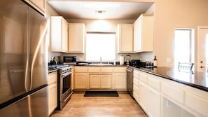 A modern kitchen with stainless steel appliances, a microwave, and a sink. - Charm on Chestnut by Avantstay Single-level + Fenced Yard + Gas BBQ Walk to Downtown Paso Robles (Paso Robles)