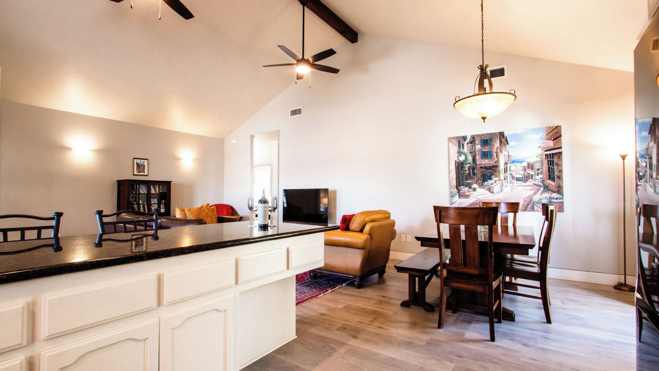 A spacious living area with a kitchen island, a dining table, and a cozy seating arrangement.