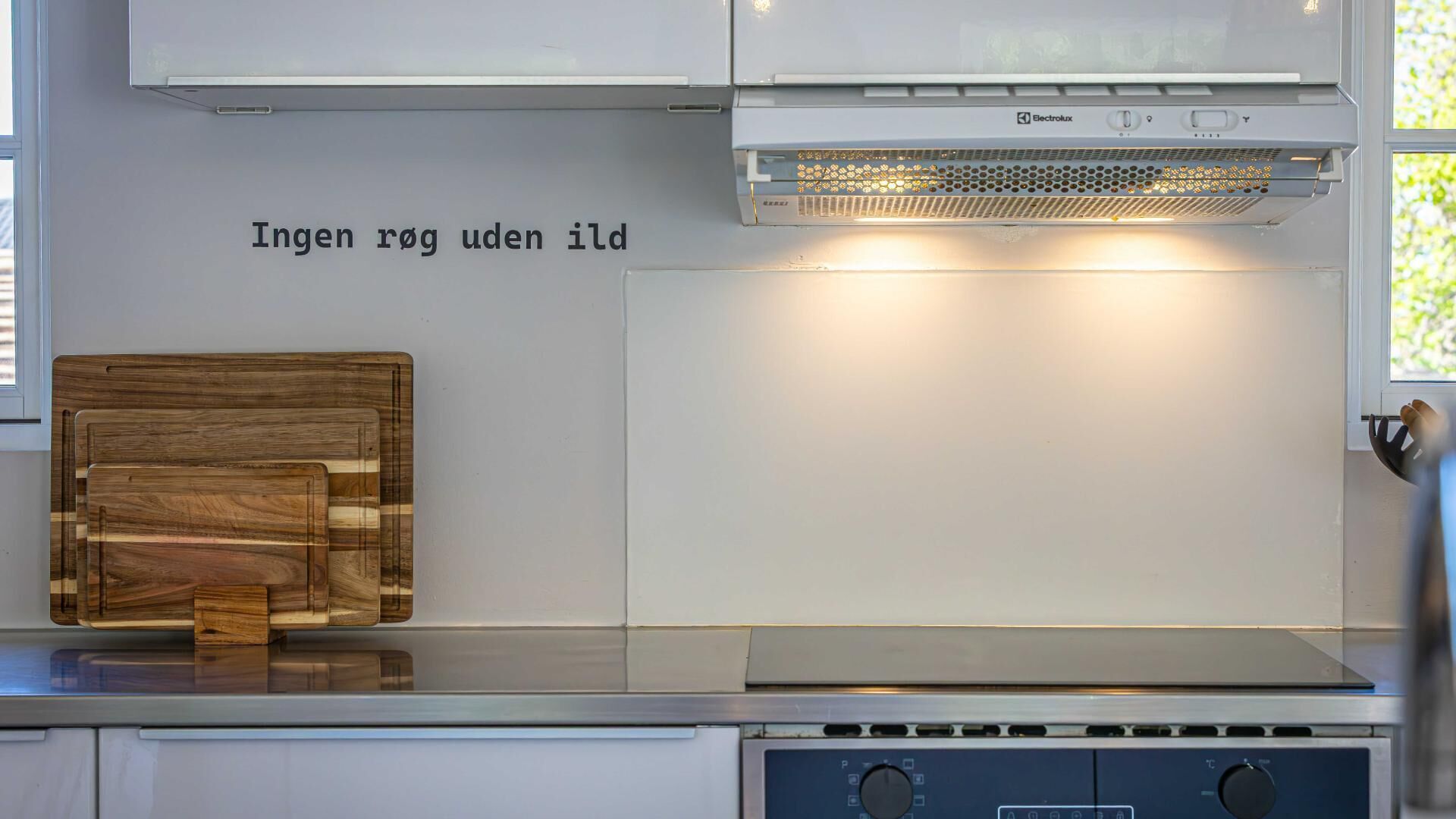 Una cocina con tabla de cortar de madera, estufa y horno empotrado.