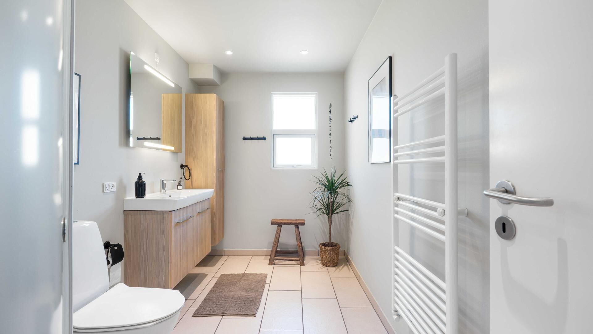 Et moderne badeværelse med toilet, vask og bruseområde.