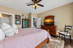 A bedroom with a bed, dresser, chair, and a ceiling fan. - Heavenly Haven - Lake Nottely | Double Decker Dock | Firepit (Blairsville)