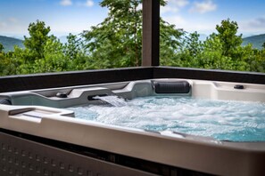 A hot tub with a view of green trees and mountains in the background. - Raccoon Ridge - Mountain View | Pet Friendly | Hot Tub | Game Room | Firepit (Blue Ridge)