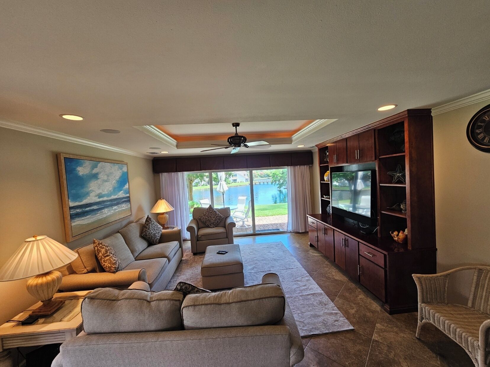 A living room with a sofa, armchairs, a coffee table, a TV, and a fireplace.