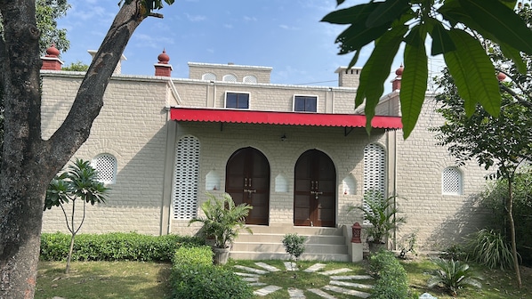 A building with a red roof, arched entrance doors, and a brick facade.