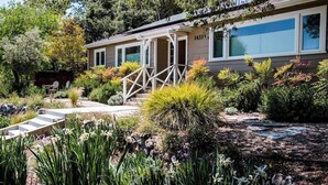 A house with a covered porch, a number '1433' on the wall, and a garden with various plants and a stone pathway. - Two Sweet by Avantstay Walk to Downtown + Private Patio Historic Paso Robles Wine Country (Paso Robles)