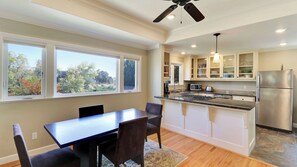 A modern kitchen with a central island, built-in cabinets, and a dining area with a table and chairs. - Two Sweet by Avantstay Walk to Downtown + Private Patio Historic Paso Robles Wine Country (Paso Robles)