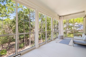 A spacious room with large windows offering a view of a forested area. - Next to Camp Watercolor and Watercolor Publix (Santa Rosa Beach)
