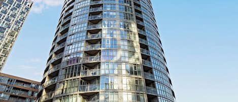 A modern high-rise building with a curved facade and multiple balconies.