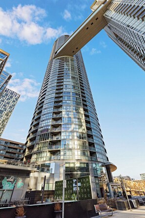 Un moderno edificio de gran altura con fachada curva y varios balcones.