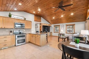 A spacious kitchen with wooden cabinets, a central island, and a ceiling fan.