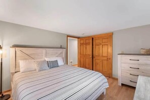 A bedroom with a bed, a dresser, and a wardrobe.