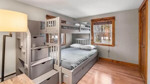 A room with a bunk bed, a desk with drawers, and a window with a view. - Breakaway Lake House (Northwood)