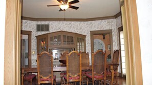 A dining area with a wooden table and chairs, a ceiling fan, and a view of a kitchen. - Jany House by Avantstay Historic Craftsman + Garden Patio Walk to Downtown Paso (Paso Robles)