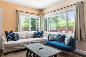 Ein Wohnzimmer mit einem beigen Sofa, einem blauen Sofa und einem Couchtisch.