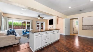 A spacious living area with a large island, a sofa, and a ceiling fan.
