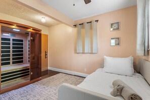 Ein Hotelzimmer mit Bett, Badezimmer mit Dusche und einem Holzschrank.