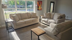 A living room with two sofas, a coffee table, and a floor lamp.