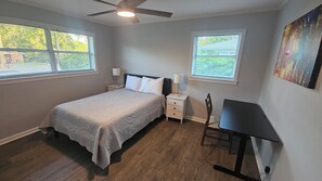A bedroom with a bed, nightstands, a desk, and a ceiling fan. - Open floor-plan - Large Covered Patio - Kitchen Island - 5 beds (Dothan)