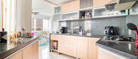 A modern kitchen with wooden cabinets, a central island, and a built-in stove.