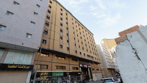 A multi-story building with a ground-level commercial area, featuring shops and a visible entrance. - Safeer Almisk Hotel Mecca (Makkah)