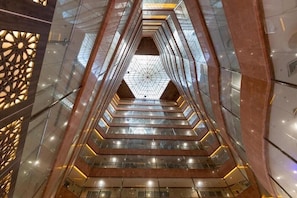 A multi-level interior with glass railings and geometric patterns. - Safeer Almisk Hotel Mecca (Makkah)