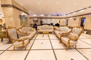 A spacious lobby with a central seating area featuring ornate sofas and armchairs, a marble floor, and a high ceiling with recessed lighting. - Safeer Almisk Hotel Mecca (Makkah)