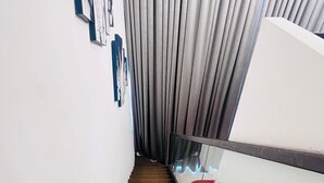 A staircase with a glass handrail and a red object on the right. - EBS PROPERTIES (Accra)