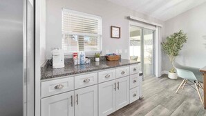 A modern kitchen with white cabinetry, a granite countertop, and a window with blinds. - Near WEC, Pet Friendly, King Beds & Spacious House (Ocala)