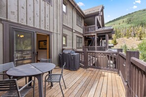 A wooden deck with a table and chairs, a barbecue grill, and a staircase leading to an upper level. - Copper Mountain views, walk to the lifts ! 3 BR 3 BA sleeps 8 (Copper Mountain)