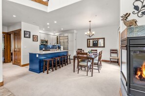 A modern kitchen with white cabinets, a blue backsplash, and a central island with stools. - Copper Mountain views, walk to the lifts ! 3 BR 3 BA sleeps 8 (Copper Mountain)
