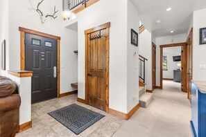 A hallway with a black door, a wooden door, and a staircase leading to another level. - Copper Mountain views, walk to the lifts ! 3 BR 3 BA sleeps 8 (Copper Mountain)