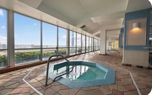 A swimming pool with a view of the cityscape through large windows. - Daytona Beach Resort OceanView condo (Daytona Beach)