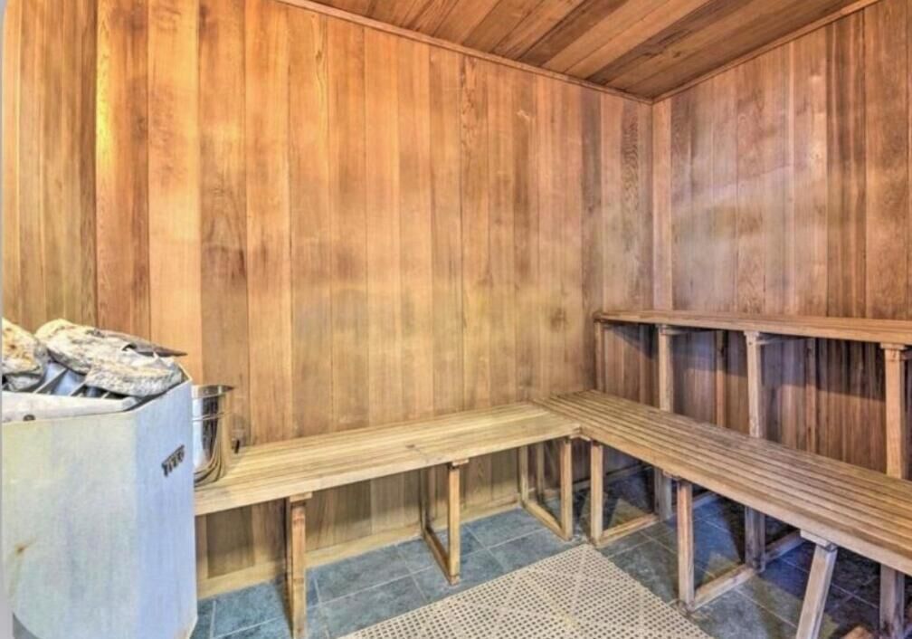 A sauna room with wooden benches and a sauna heater.