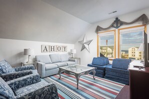 A living room with a sofa, armchairs, a coffee table, and a star decoration on the wall. - Captains Choice-KDH MP 7, Oceanside, Pool, Hot Tub, Pets OK, YR Flex Stays (Kill Devil Hills)
