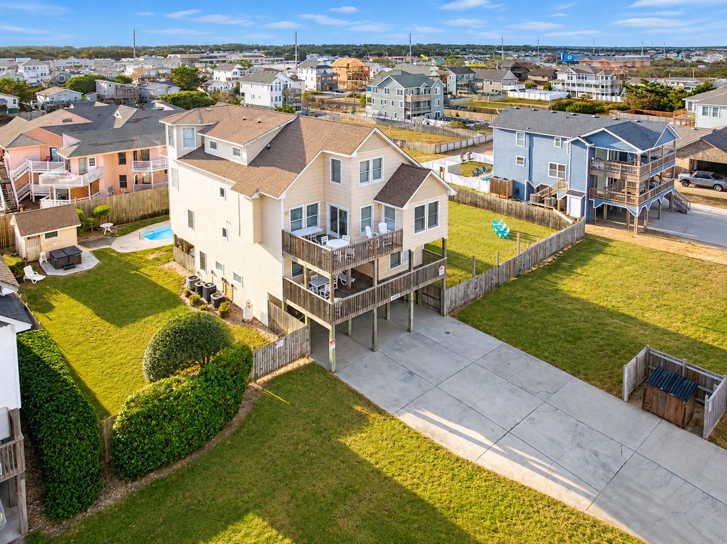A residential area with houses, a swimming pool, and a wooden deck.