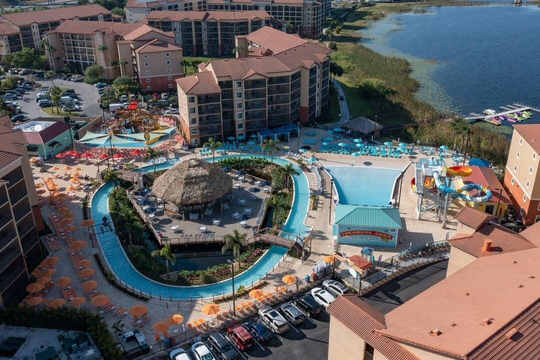 Un complexe hôtelier doté de plusieurs piscines, d’un parc aquatique et d’un espace central aménagé autour d’une piscine circulaire.