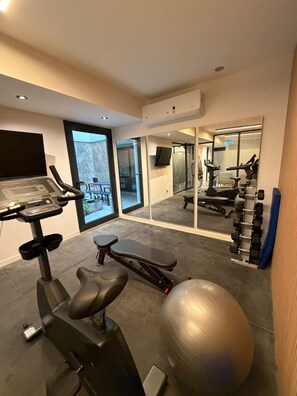 A home gym with exercise equipment including a treadmill, stationary bike, and weights. - Comfortable and Elegant Vitraux Recoleta (Buenos Aires)