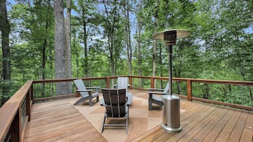 Una terrazza con posti a sedere all'aperto e un riscaldatore portatile.