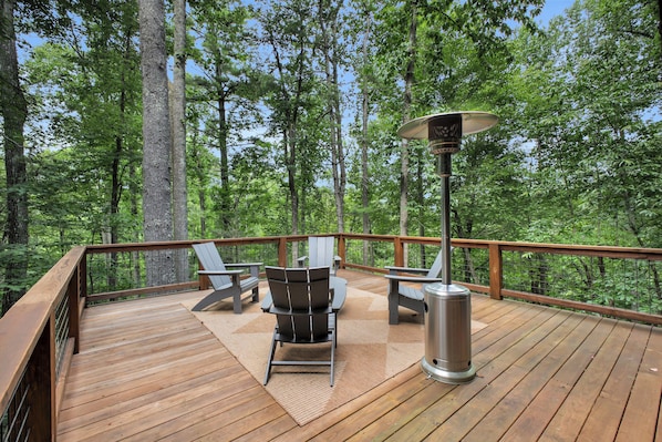 A deck with outdoor seating and a portable heater.