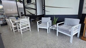 A room with white furniture, a wall with 'SUNDANCE' branding, and a grill area. - 2-bedroom campground in peaceful Key Largo with AC comfort. (Key Largo)