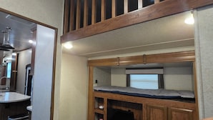 A compact room with a bunk bed, a small kitchenette, and a window with blinds. - 2-bedroom campground in peaceful Key Largo with AC comfort. (Key Largo)