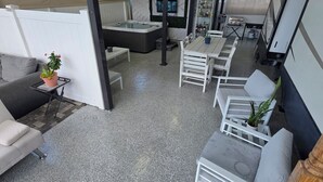 A covered outdoor seating area with a hot tub, tables, and chairs. - 2-bedroom campground in peaceful Key Largo with AC comfort. (Key Largo)
