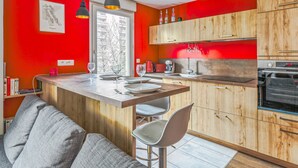 Une cuisine moderne avec des meubles en bois, un îlot central et des luminaires suspendus.