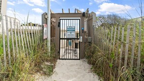 A gated entrance to a private property with a sign indicating beach access. - Ground Floor Condo | 2 King Suites | Beach (Panama City Beach)