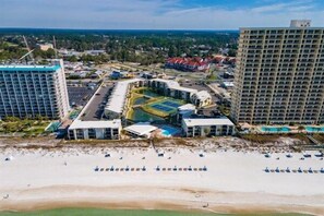 An aerial view of a resort with a beach, multiple buildings, and a pool area. - Ground Floor Condo | 2 King Suites | Beach (Panama City Beach)