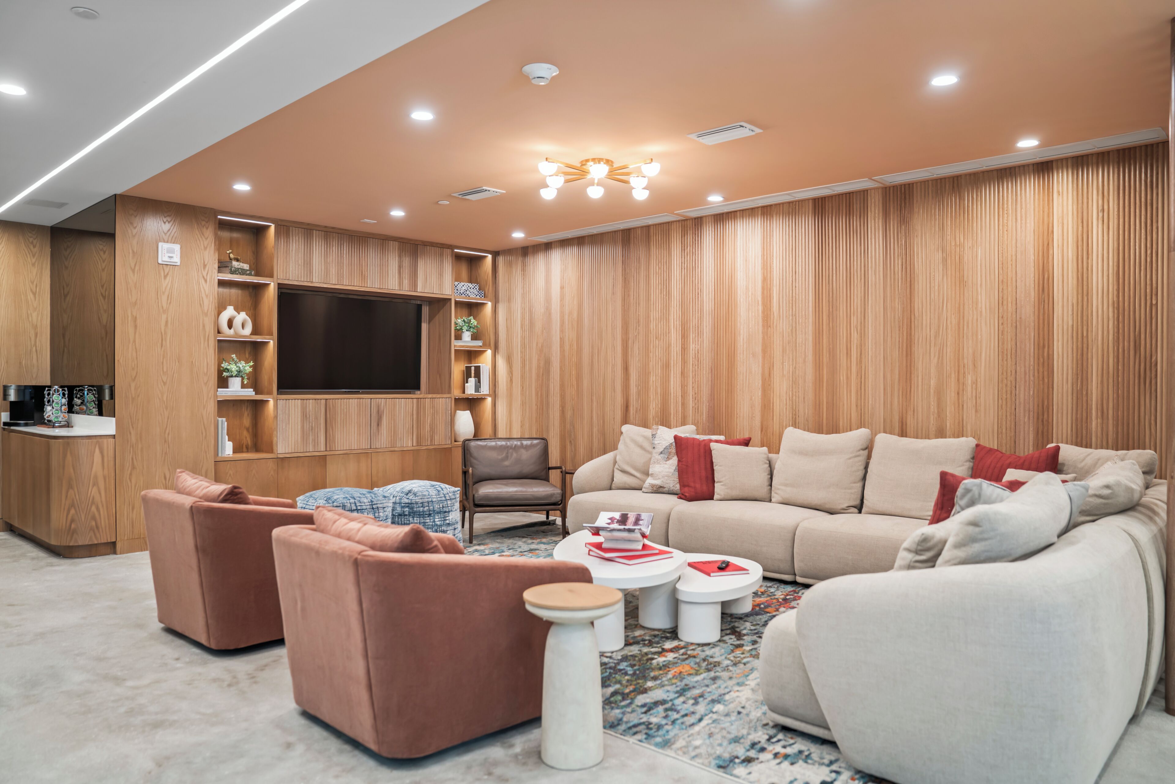 A modern living room with a sofa set, a coffee table, and a television mounted on the wall.