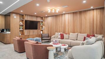 A modern living room with a sofa set, a coffee table, and a television mounted on the wall.