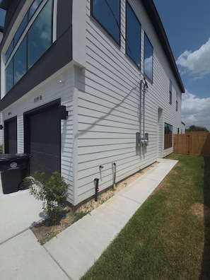 A modern two-story house with a garage, a small front yard, and a wooden fence. - NEW! Houston Retreat, Near Medical District, NRG Stadium & Downtown (Houston)