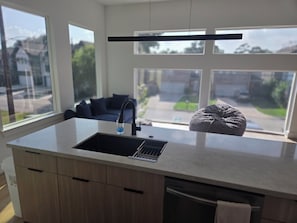 A modern kitchen with a large window, a built-in sink, and a countertop. - NEW! Houston Retreat, Near Medical District, NRG Stadium & Downtown (Houston)